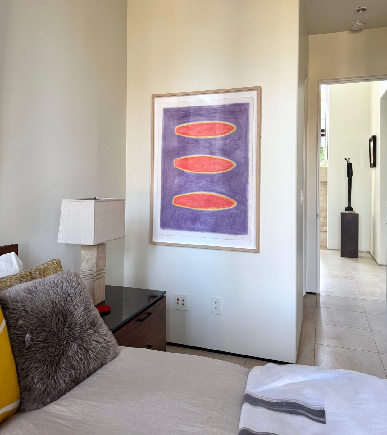 Guest bedroom with a purple and orange Lori Brunner painting above the nightstand
