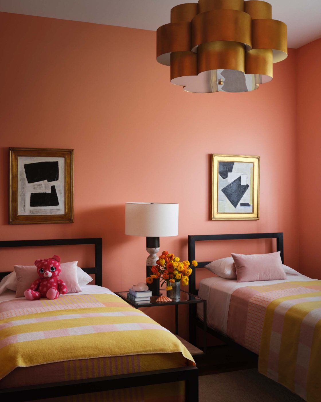 Salmon-pink guest bedroom with twin beds and two Lori Brunner paintings